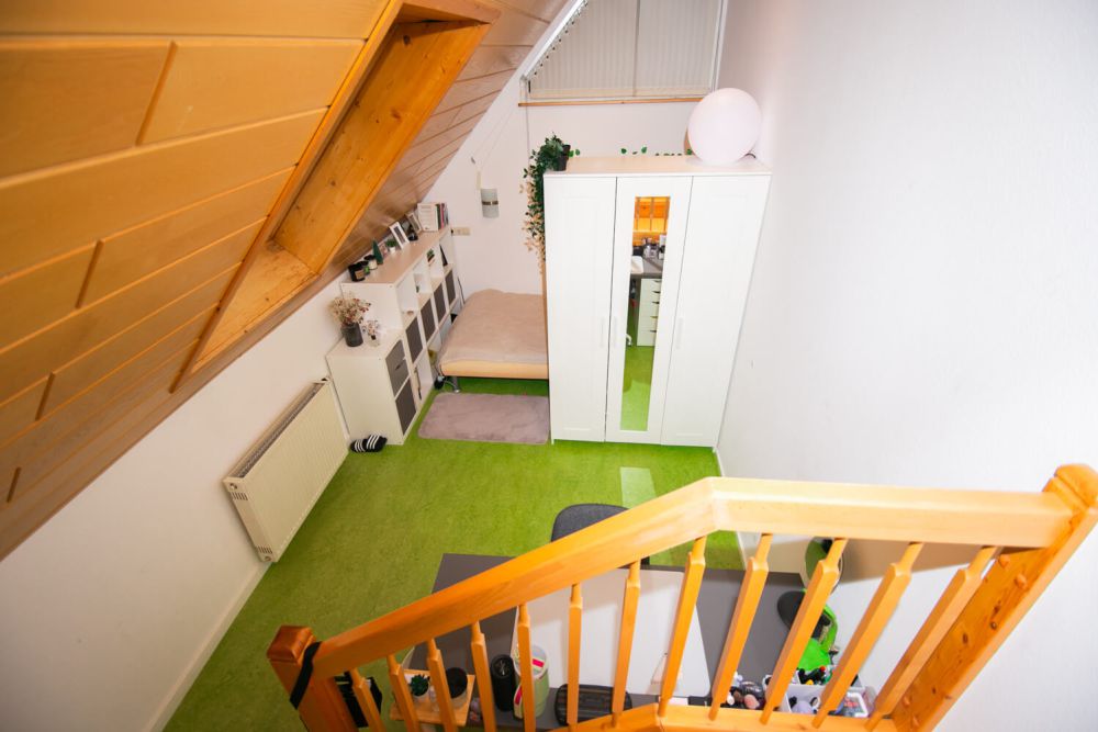 Einzelzimmer mit Treppe zu einer kleinen oberen Ebene im Studentenwohnheim City in Furtwangen