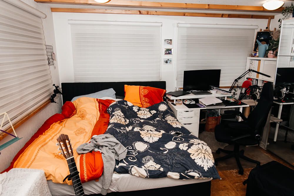 Persönlich gestaltetes Schlafzimmer mit Gitarre und gemütlichem Bett im Studentenwohnheim City