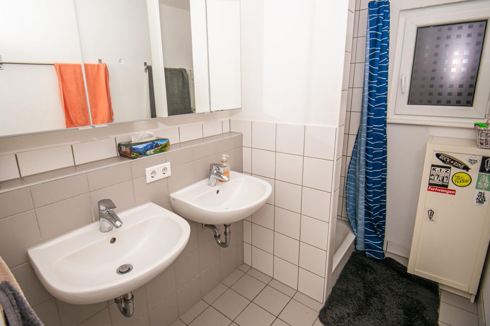 Zwei weiße Waschbecken mit Spiegelschrank im Badezimmer des Studentenwohnheims Solar