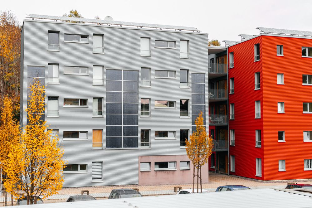 Herbstbaum in leuchtendem Orange vor dem roten Gebäude des Studentenwohnheims Solar in Furtwangen